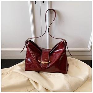 Détail du sac hobo bordeaux montrant la texture du cuir ciré et les finitions dorées