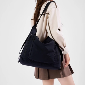 Side view of black large capacity nylon tote bag showing multiple zipper pockets
