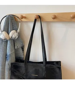 Detail einer schwarzen glänzenden Tragetasche mit goldenem FASHION & BAGS Schriftzug