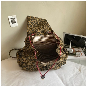 Detail of leopard print canvas backpack with striped lining and red drawstring closure