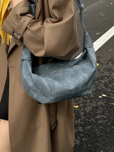 Vintage blue crescent shoulder bag with knotted strap and distressed leather texture