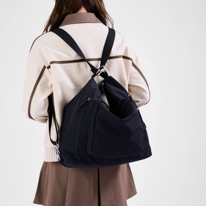 Rear view of black nylon multi-zipper backpack showing storage layers and silver buckles