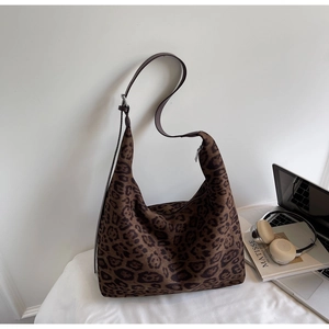 Detailed macro view of large leopard print hobo bag with adjustable brown strap and zip closure