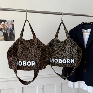 Détail de cabas en toile à imprimé léopard en marron et gris-vert avec bandoulière