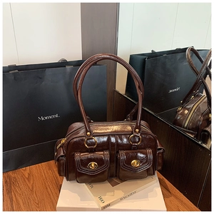 Detail view of dark brown patent leather bag with gold twist-lock pockets and glossy finish