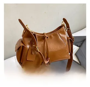 Detail of vintage brown glossy leather tote bag with side pocket and gold buckle