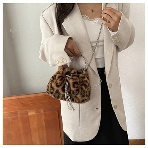 Detail of leopard print faux fur bucket bag featuring silver chain and drawstring tassels