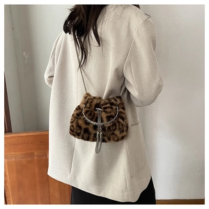 Detail of leopard print faux fur crossbody bag with metal chain and tassel charm