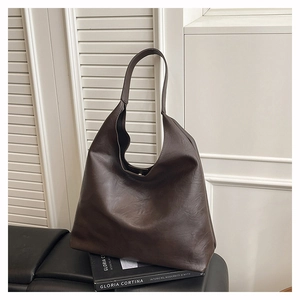 Detail of soft brown faux leather texture on large hobo tote bag with wide strap