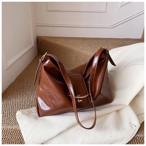 Vue détaillée du sac cabas en cuir marron brillant avec boucle métallique dorée chic