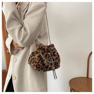 Detail of plush leopard print bucket bag with silver chain strap and metal tassels