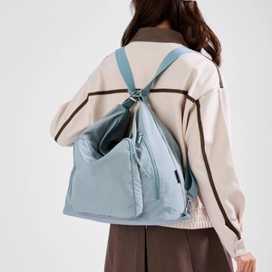 Light blue waterproof nylon backpack detail showing side zipper and adjustable strap