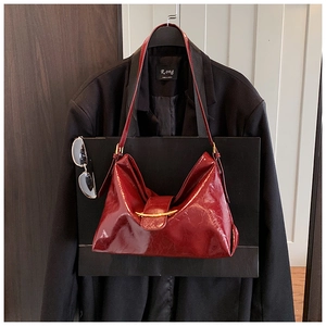 Détail de ce sac fourre-tout en cuir verni rouge foncé brillant avec boucle en métal