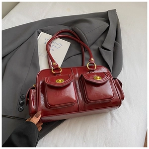 Close-up of vintage dark wine red underarm bag with double front pockets and gold locks