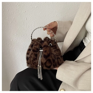 Detail of leopard print faux fur bucket bag with silver metal handle and tassel