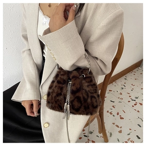 Close-up of leopard print faux fur bucket bag with chain strap and tassel detail