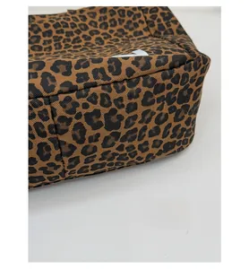 Vue détaillée de la base renforcée d'un sac cabas en toile tendance à imprimé léopard