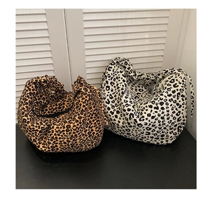 Detailed view of leopard print canvas tote bags with pleated texture and zipper closure