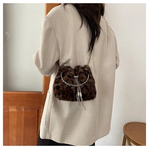 Detailed view of leopard faux fur bucket bag with silver chain and tassel on model
