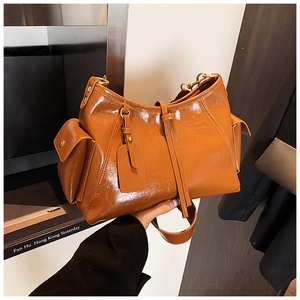 Detail of caramel vintage tote bag featuring side pockets and retro tassel fringe