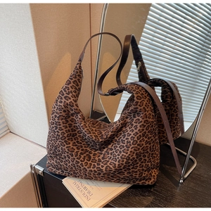 Detail of hobo bag featuring leopard pattern fabric and smooth brown leather shoulder strap