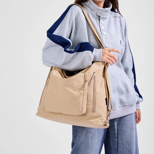 Macro view of khaki multi-pocket tote bag showing the waterproof nylon fabric texture