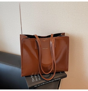 Detailansicht der geprägten Fashion & Bags Schrift auf der braunen Leder Tragetasche