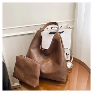Detail view of large brown faux leather hobo bag with vintage texture and matching pouch