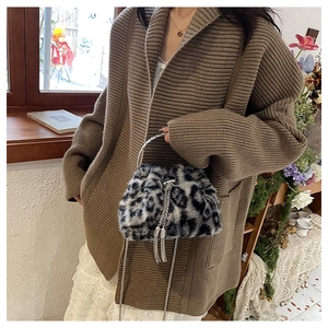 Close-up of leopard print faux fur handbag with silver circular handle and metal tassel