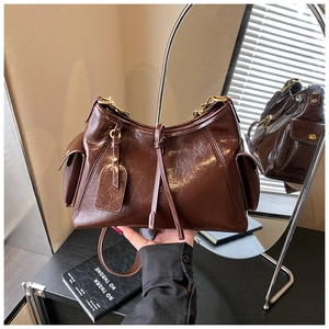 Detail of retro dark brown tote bag with glossy leather texture and metal buckles