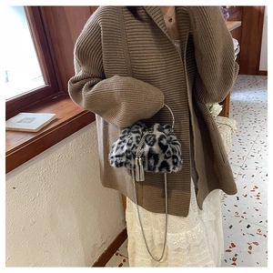 Detail of leopard print faux fur bucket bag with silver metal ring handle and chain