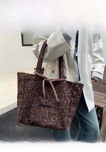 Detail of leopard print faux suede tote bag with bow tie and silicone brand tag