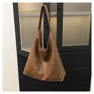Detailed view of the textured brown PU leather and soft drapery on a large tote bag