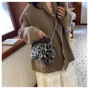 Furry leopard bucket bag styled with a knitted cardigan and lace skirt in a warm room