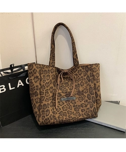 Detail of leopard print suede tote bag with front pocket and decorative bow accent