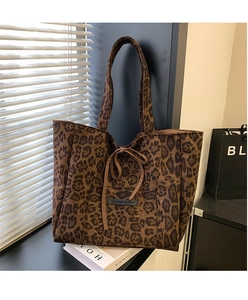 Detail of faux suede leopard print tote bag with tie closure and branded front pocket