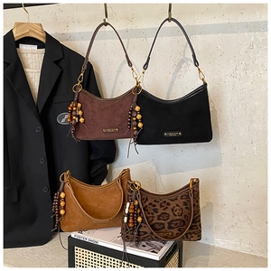Detail of four crescent bags in brown, black, camel and leopard print with beaded charms
