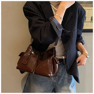 Detail of vintage brown patent leather tote bag with side pockets and glossy finish