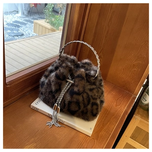 Detail of leopard print faux fur bucket bag with sparkling rhinestone tassel and metal handle