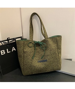Detail of olive leopard print tote bag with bow knot and 'OWN THE MOMENT' leather tag