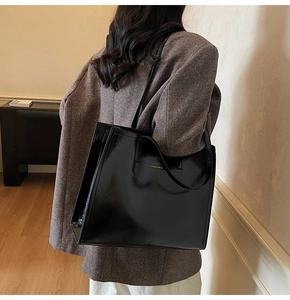 Detail der glänzenden schwarzen Lackleder-Einkaufstasche mit Fashion & Bags Logo-Schriftzug