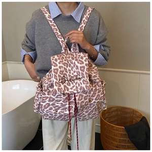 Close-up of leopard print canvas backpack showing drawstring closure and flap cover