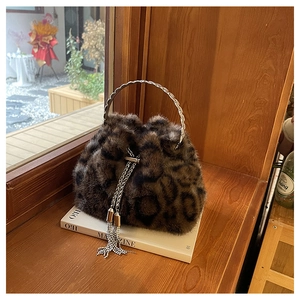 Close-up of leopard print faux fur bucket bag with silver ring handle and tassel details