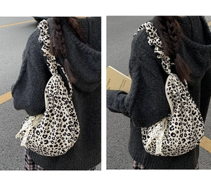 Detail of leopard print tote bag featuring ruffled shoulder straps and lace fringe accents