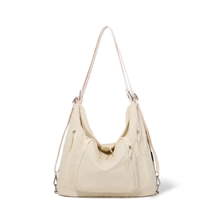 Detail view of cream nylon tote bag with multi-zipper pockets and silver hardware