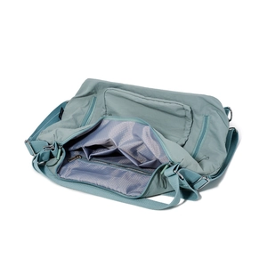 Detail view of the pale green tote bag showing interior honeycomb lining and storage pockets
