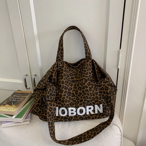 Vue détaillée du sac cabas en toile léopard avec texte JOBORN et bandoulière amovible