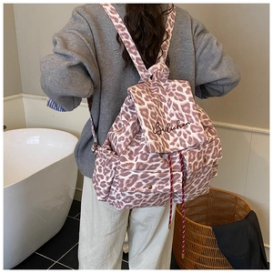 Close-up of pink leopard print canvas backpack with embroidery and drawstring detail