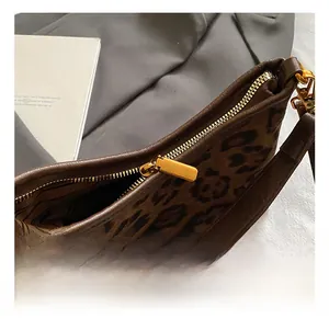 Close-up of high-quality gold metal zipper and hardware on leopard print shoulder bag