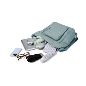 Flat lay of pale green nylon tote bag showing spacious storage for laptop and gadgets